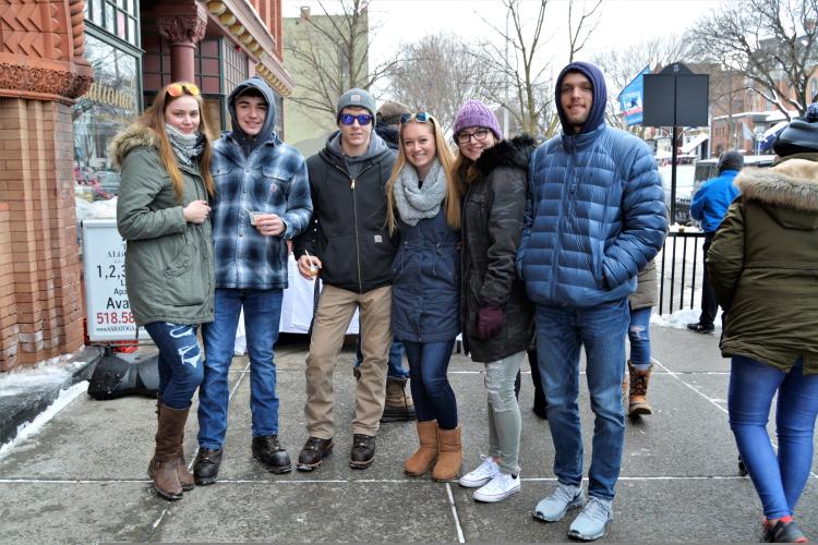 Group of attendees posing on sidewalk