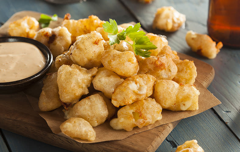 Deep-fried cheese curd with a side of dipping sauce