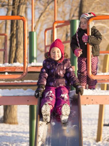 Girls playing on a snowy slide