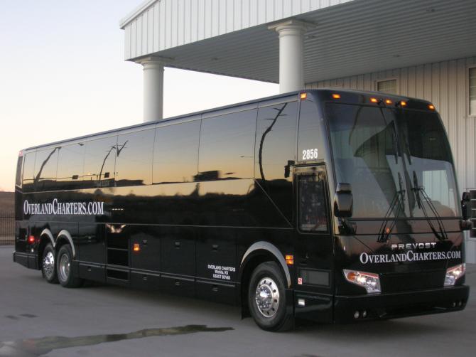 A black tour bus prepares to depart Overland Charters in Wichita