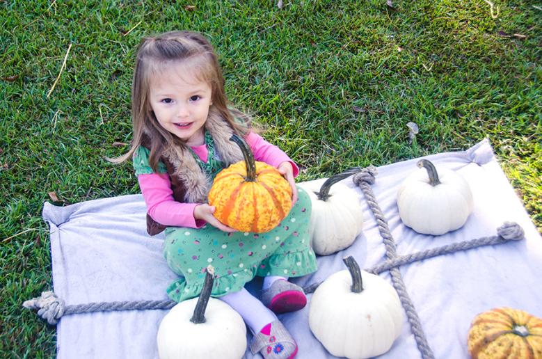 Little Girl Holding a Pumpkin