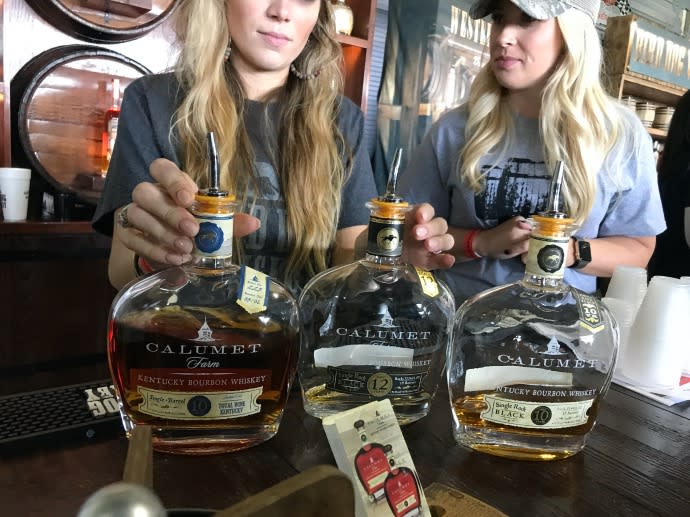 Women holding bourbon bottles during the BG Bourbon and Brewfest in Bowling Green Kentucky