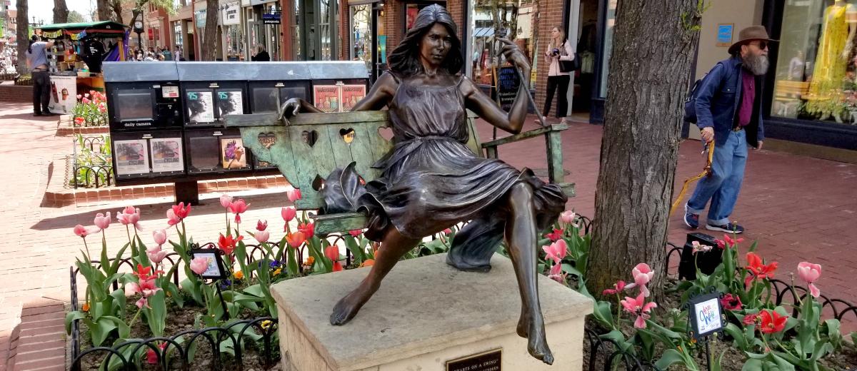 Pearl Street sculpture of a woman on a swing