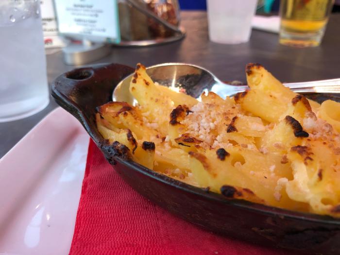 Fire Works Mac and Cheese in a skillet dish with Parmesan cheese and toasted tips