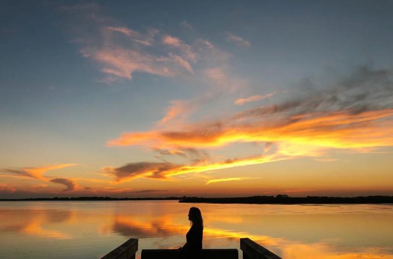 Woman On Dock By Water At Back Bay National Wildlife Refuge In Virginia Beach