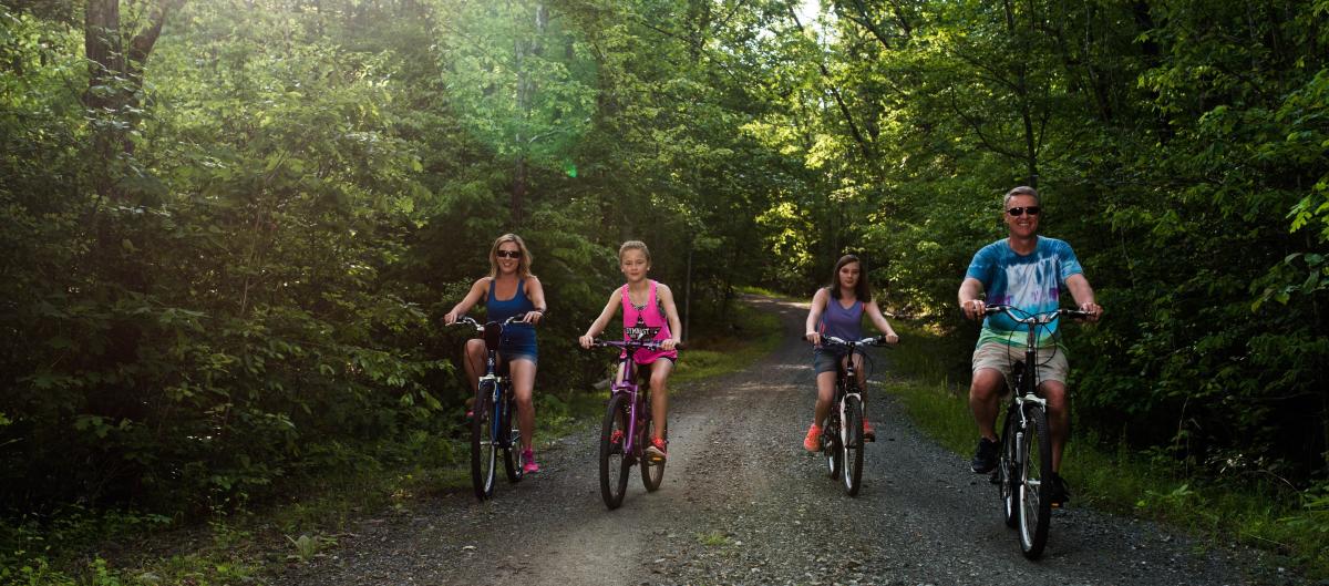 family biking on a path in the forest