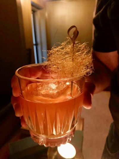 Gourmet cocktail garnished with spun sugar from The Light of Seven Matchsticks bar