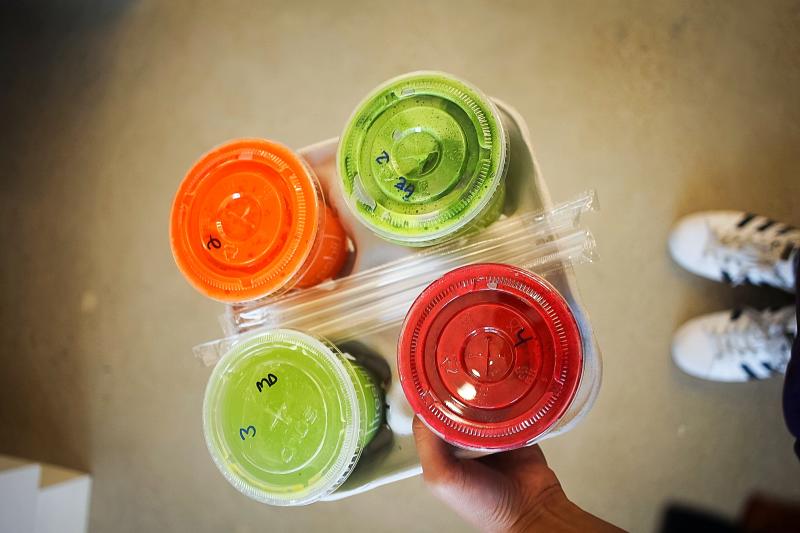 Freshii carrying tray of different juices