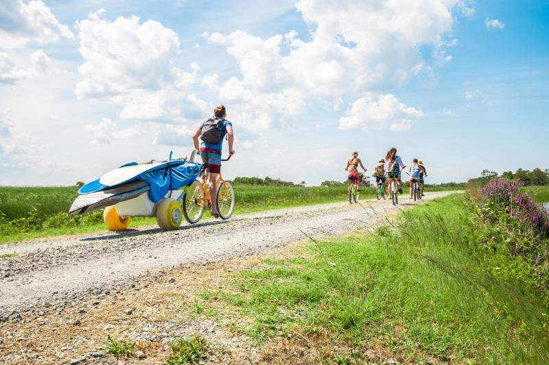 Visitors cycle down a gravel bike path in Sandbridge near Virginia Beach.