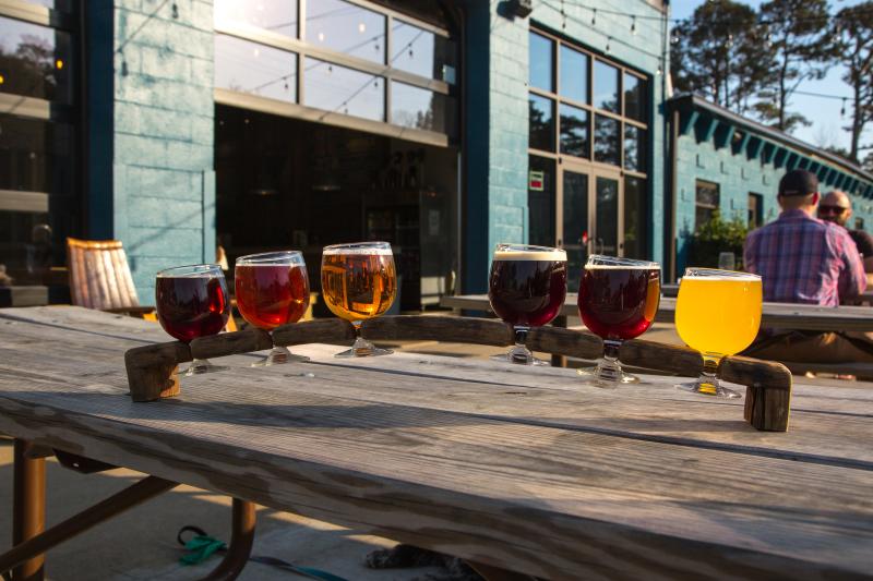 A sample of drinks are served on a picnic table outside at Commonwealth Brewing Company.