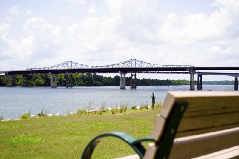 Ditto Landing in Huntsville, Alabama with a bridge, river, and bench.