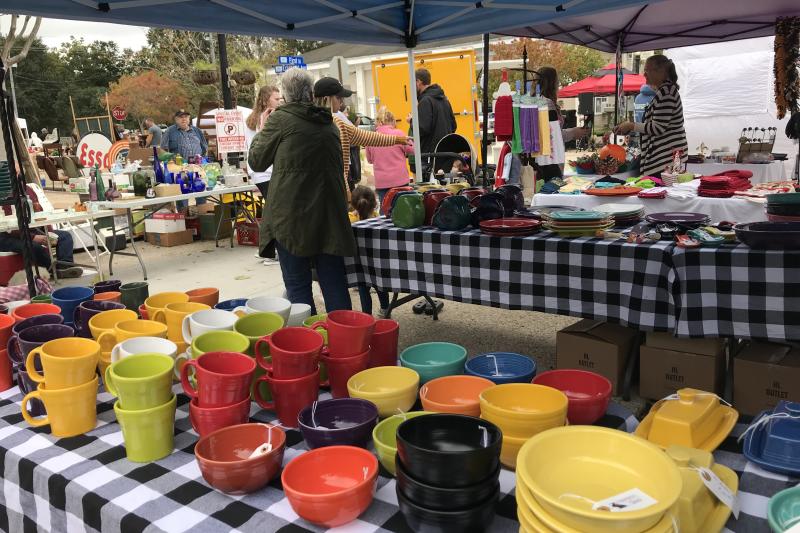 A table is filled with assorted colors of Fiestaware bowls and mugs at the Slidell Antique Street Fair