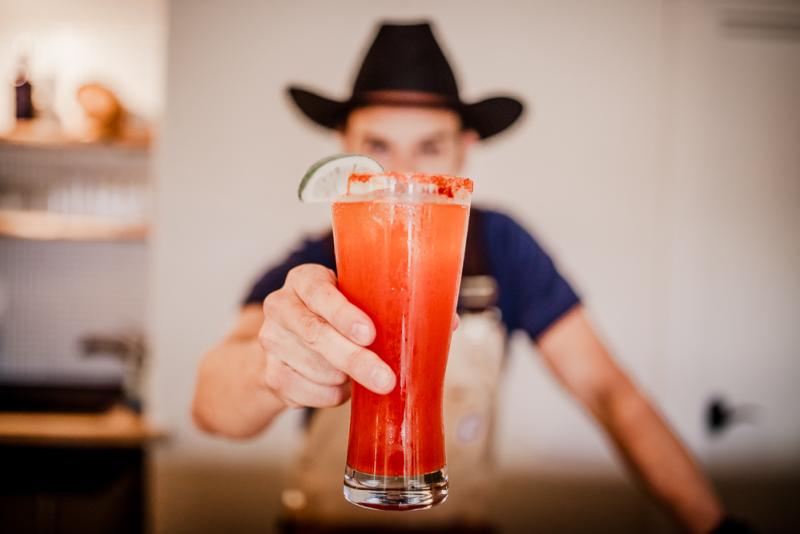 Bartender holding Michelada at Desert Door Distillery near austin texas