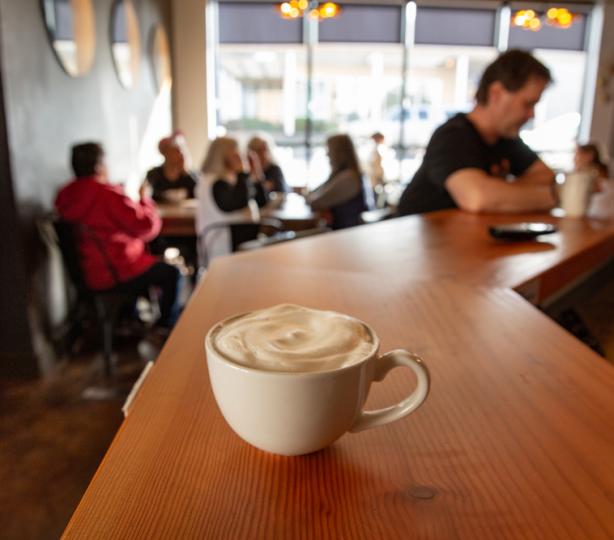 Foamy latte sitting on a coffee bar