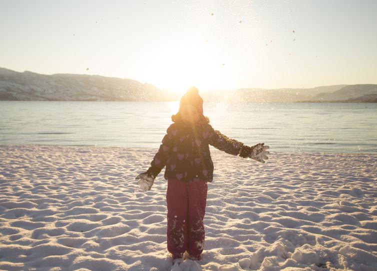 Little Girl Playing in the Snow by the Beach