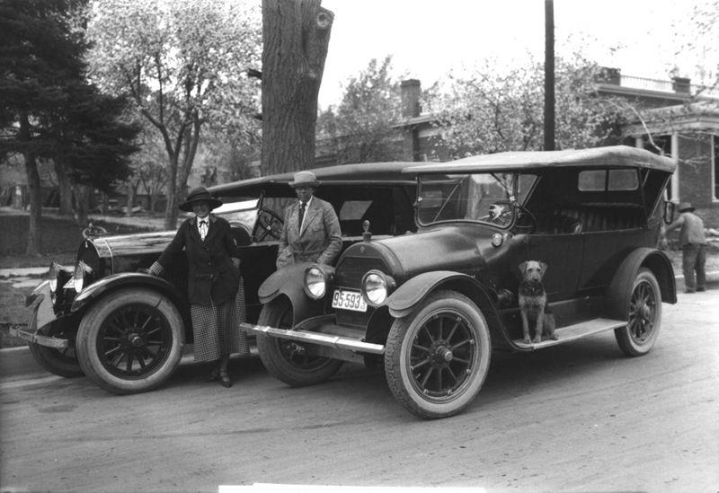 Black and white photo of Molloy and MacLeay standing next to cars