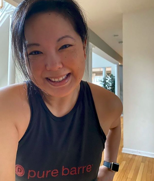 A smiling woman wearing a pure barre tank top