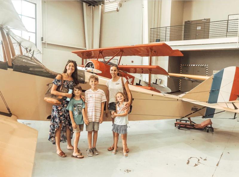 Family posing in front of an old airplane at the Military Aviation Museum