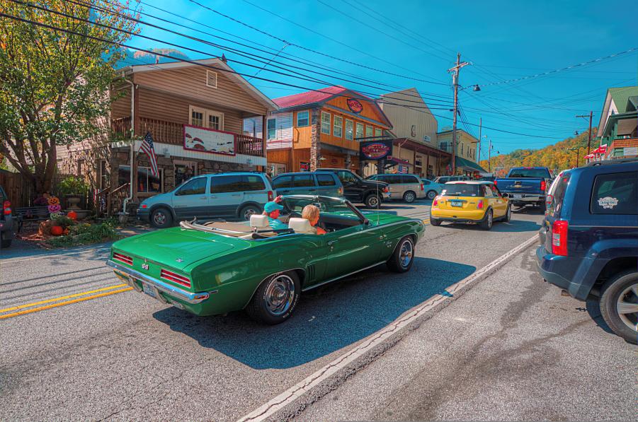 A couple drives a vintage green convertible down Main Street in Chimney Rock, NC. 