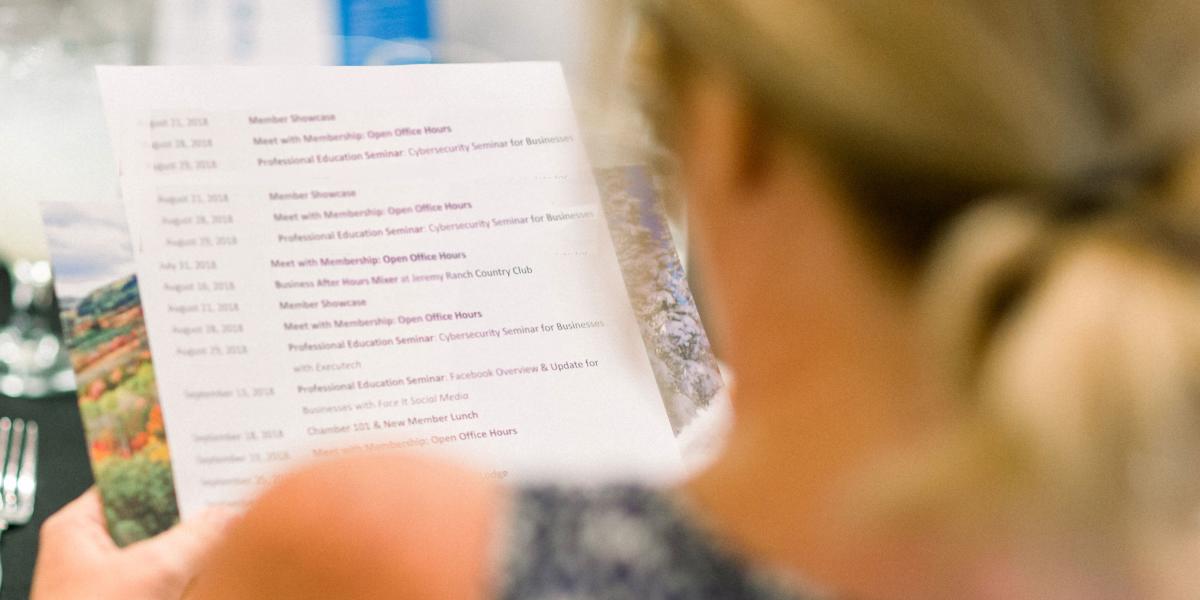 Looking over a woman's shoulder at the papers she is holding