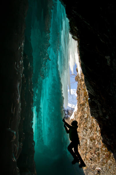 an ice climber on a frozen waterfall