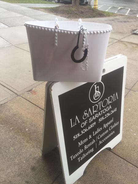 White purse on La Sartoria of Saratoga sign