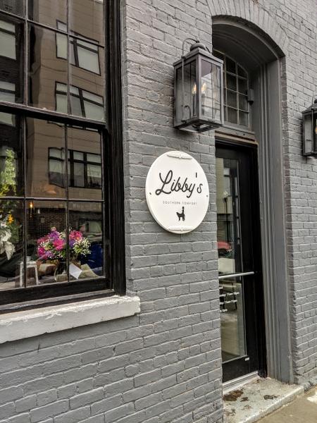 front entrance of libby's southern comfort in covington ky has a grey brick building and a white sign