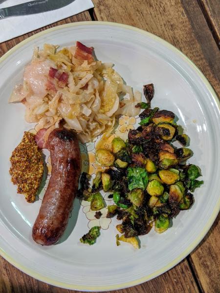 german sausage, slaw, brussel sprouts served on a plate at wunderbar in covington kentucky