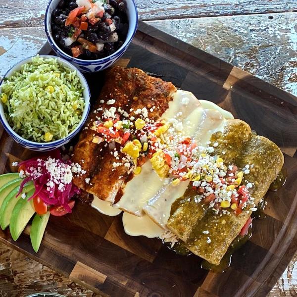 A plate of enchiladas from Mexican Sugar come with red, white, or green sauce and a side of rice & beans.