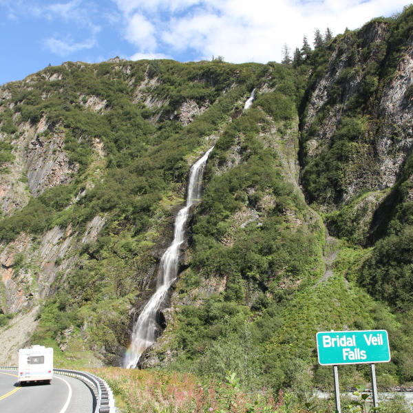 an RV drives past Bridal Veil Falls