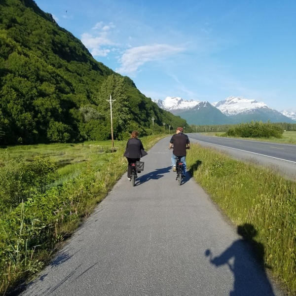 a couple rides bikes on a scenic bike path