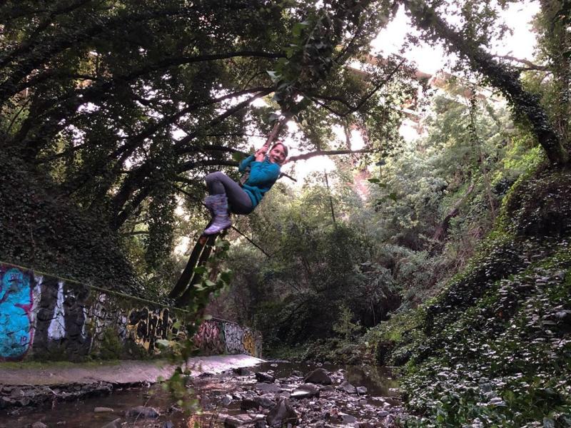 Girl swinging on a vine outdoors in Oakland