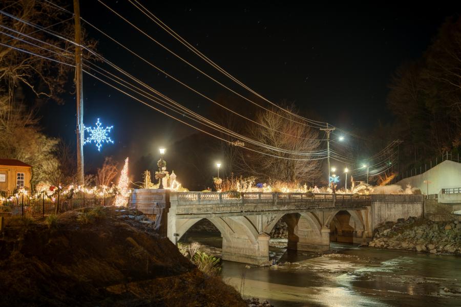 The Lake Lure Flowering Bridged decked out in enchanting Christmas lights against the dark sky.