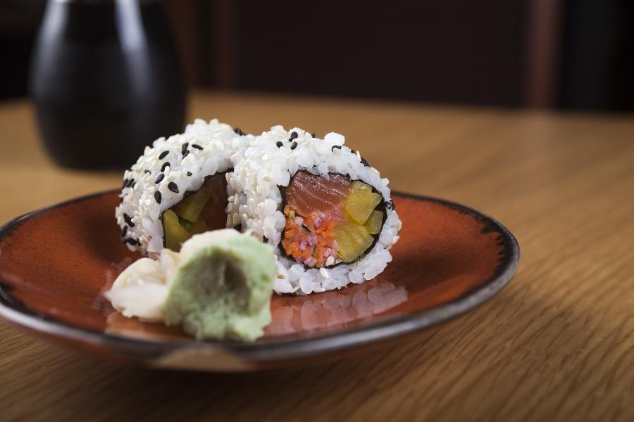 Plate of sushi and sake served in the background