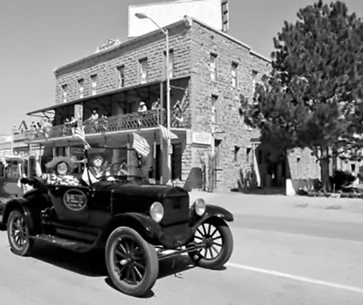 A vintage car drives down the street in front of Hotel Eklund in Clayton, NM