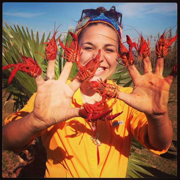 A visitor enjoys Beaumont's crawfish season by putting them on her ten fingers.