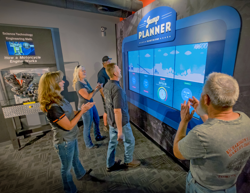 Visitors react with excitement to the Plan Your Jump interactive display at the Evel Knievel Museum in Topeka, Kansas