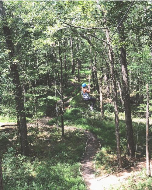 A visitor zips down a zip-line at AdventureWorks in Virginia Beach, VA.