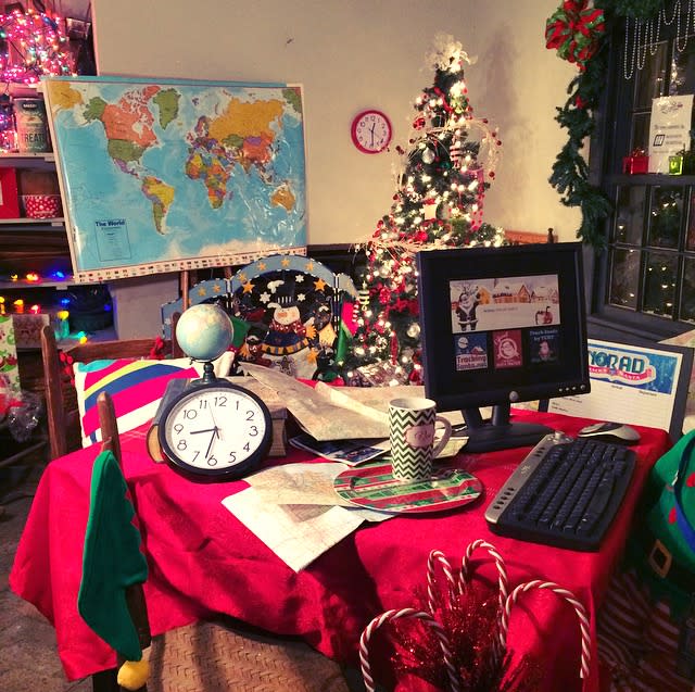 A desk with a laptop, empty plate and cup overlooks a map of the world in a replica of Santa's office at Santa's Village