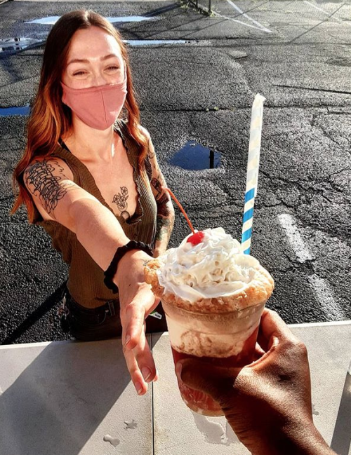 A woman picks up her vegan order from the Sprouting Dreams food truck.