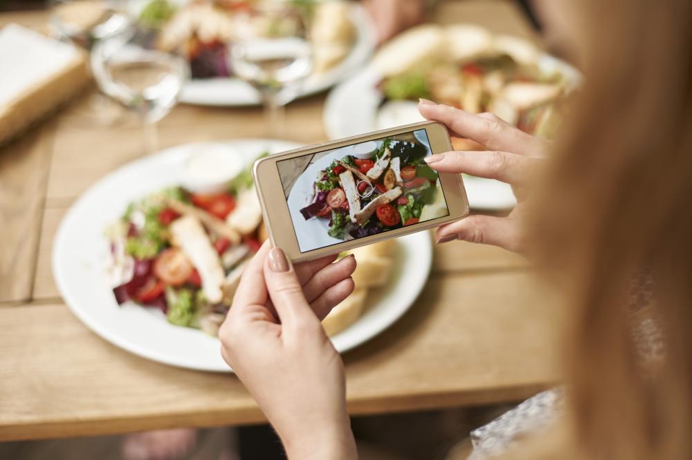 Women taking photo on her phone of her dish.