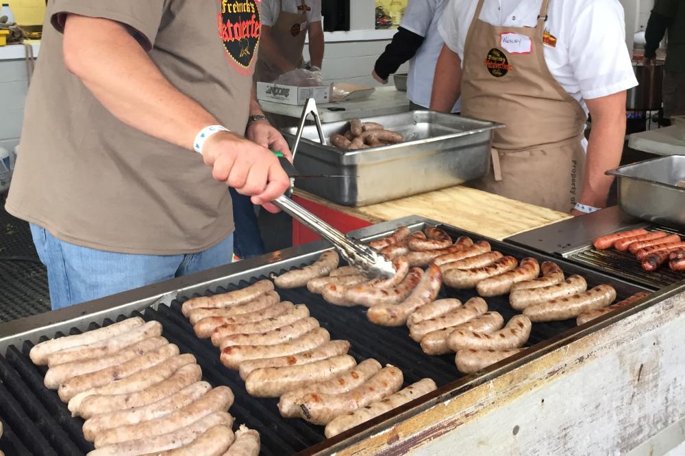 Man cooking bratwurst at Frederick Oktoberfest