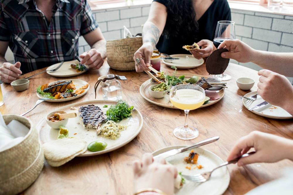 people dining family style around table at suerte in austin texas