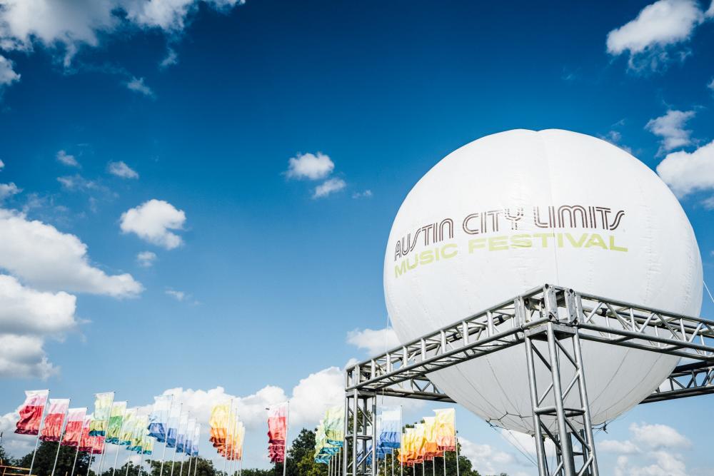 large balloon reading Austin City Limits Music Festival with colorful flags at ACL Fest in austin texas