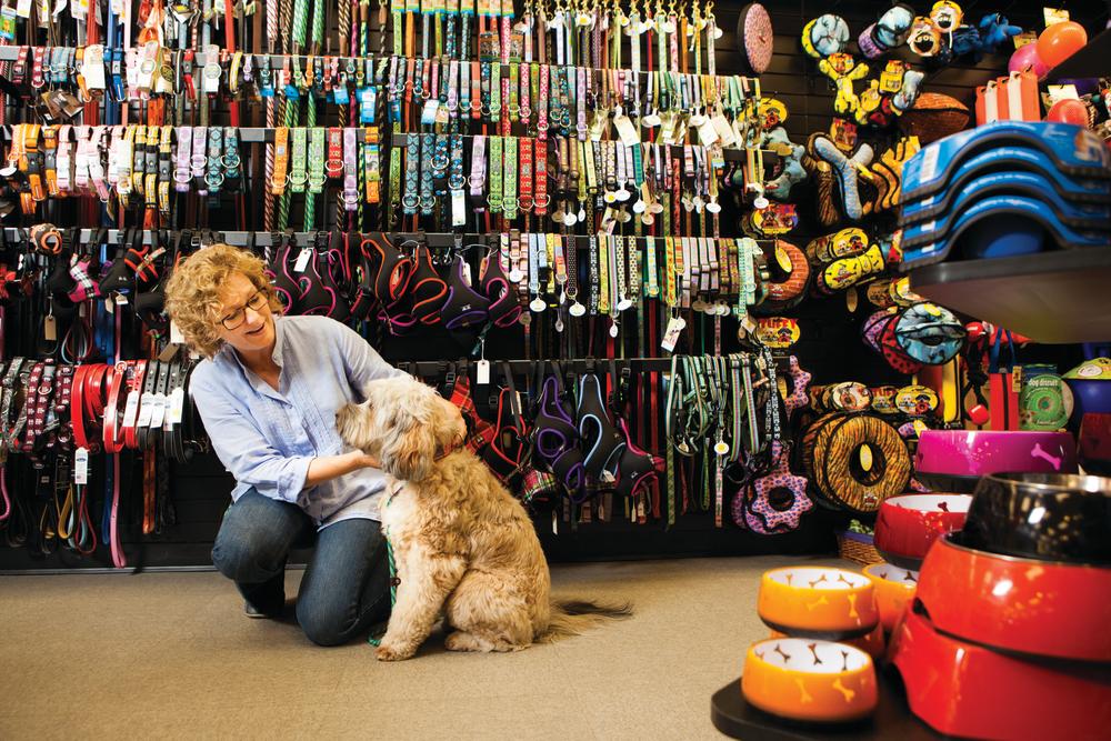 vrouw en hond winkelen voor halsbanden bij Tomlinsons Feed in austin texas