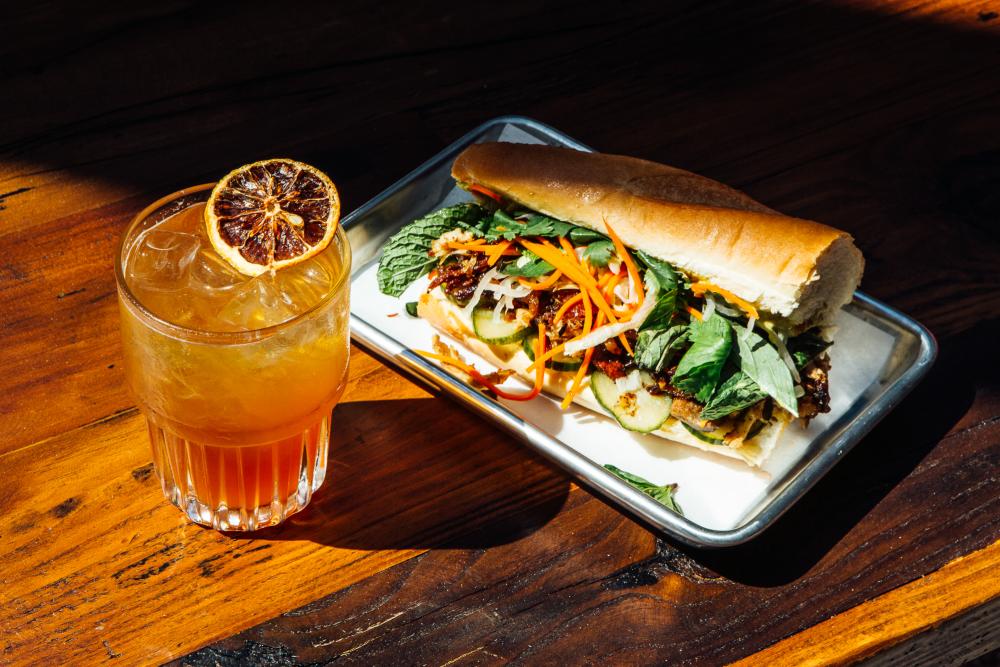 Crescent Cup cocktail and Rotissere Chicken Bahn Boy sandwich at Leftys Brick Bar at arrive east austin hotel in austin texas