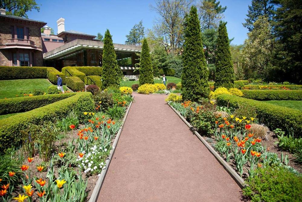 Blooming flowers and well maintained hedges framing a walkway at the Prospect Gardens at Princeton University