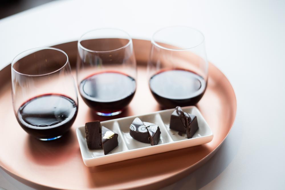 Three different glasses of wine paired with three different chocolates on a tray at Cocoa Dolce in Wichita