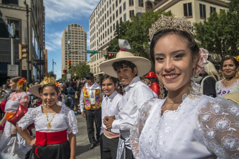 Young people dressed in traditional wear for Viva la Vida Parade during dia de los muertos celebrations in austin texas