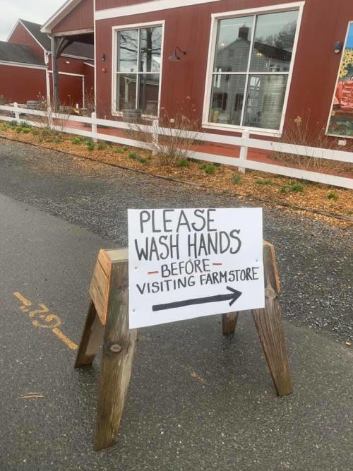 An image from Terhune Orchards with a sign that requests visitors to wash hands before entering the premises